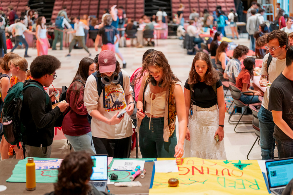 Student club representatives tabling in an auditorium.